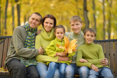 Happy smiling family relaxing in autumn parkの写真素材