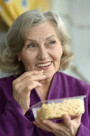 Close up of a senior woman with cookiesの写真素材