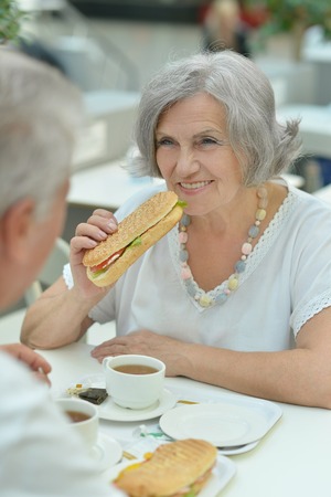 Portrait of a elderly couple eating fast foodの写真素材