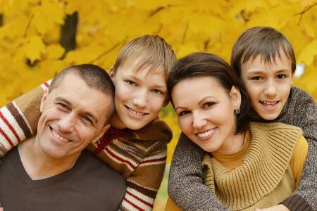 Portrait of family relaxing in autumn park