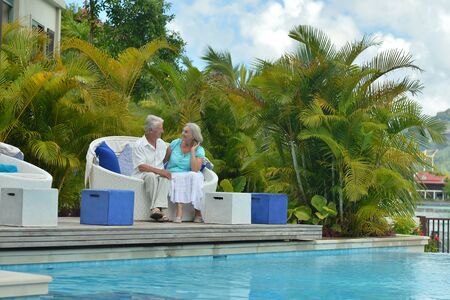 Senior couple relaxing near pool at hotel resortの写真素材