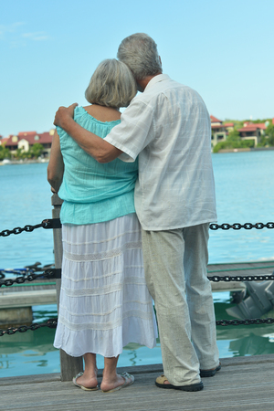 Happy cute senior couple on the pier ,back viewの写真素材