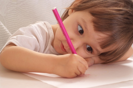 Little girl drawing at home at tableの写真素材