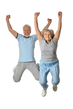 Senior couple jumping  on a white backgroundの写真素材