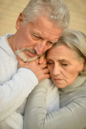 sad Mature couple near wall in the room