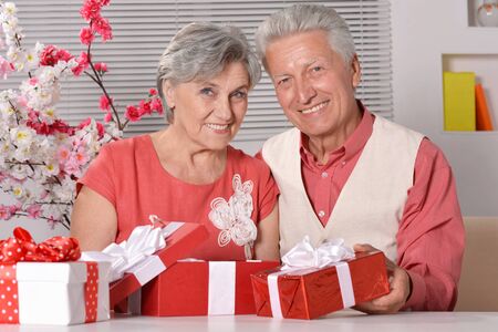 Happy beautiful elderly couple celebrating new year at homeの写真素材