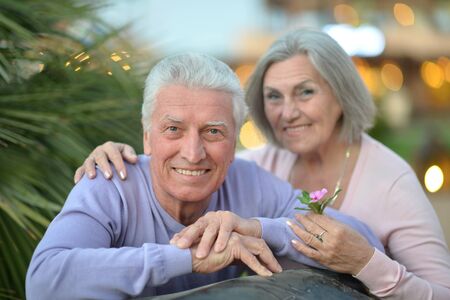 Amusing happy smiling old couple with flowers