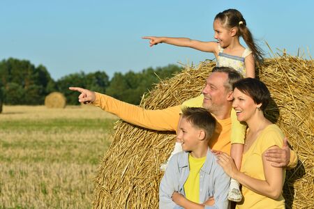 Happy family in wheat field in sunny dayの写真素材