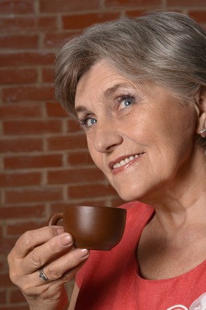 Portrait of a senior woman with cup at homeの写真素材
