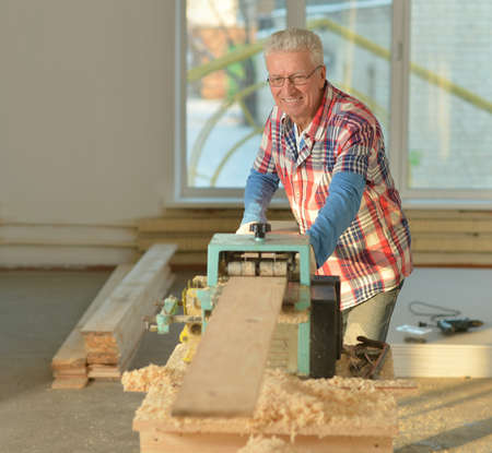 portrait of Senior man  repairing in the roomの写真素材