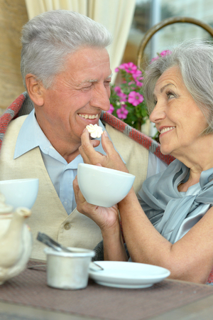 Senior couple drinking tea outside in cafeの写真素材