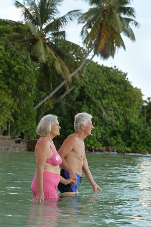 Happy elderly couple rest at tropical beachの写真素材