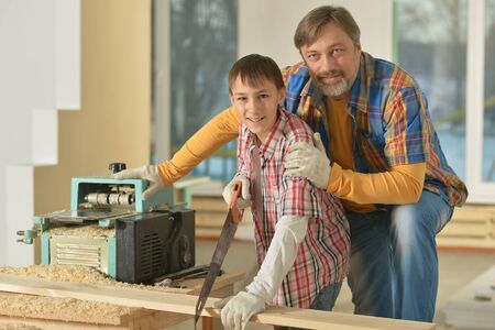 happy father and little boy  repairing in the roomの写真素材