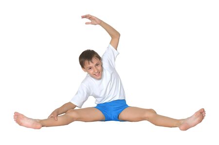 Young boy doing exercises, isolated on white backgroundの写真素材