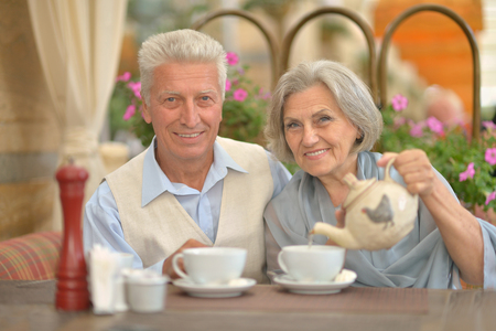 Senior couple drinking tea outside in cafeの写真素材
