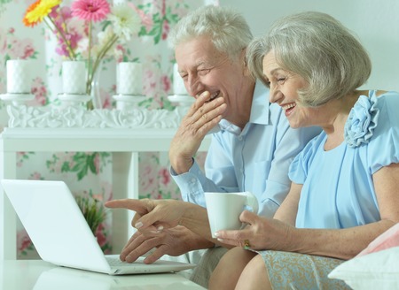 happy senior couple with laptop  at homeの写真素材