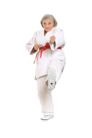 Senior woman in karate pose on white backgroundの写真素材