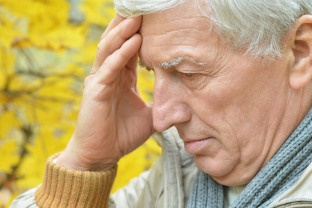 Portrait of senior man thinking about something outdoorの写真素材