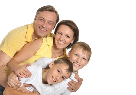 Happy family of four standing on a white background