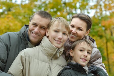 Happy family relaxing in autumn park together