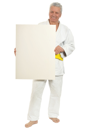 Karate  Senior man   with white poster on white backgroundの写真素材