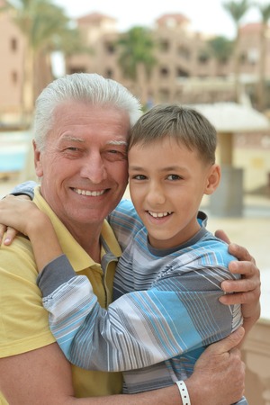 Happy senior man with grandchild relaxing at vacation resortの写真素材