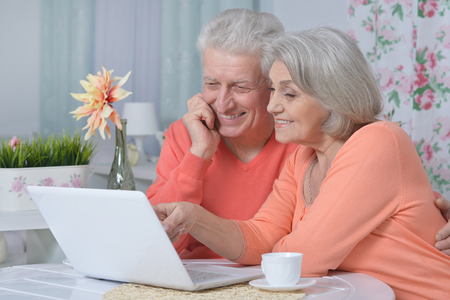 happy senior couple with laptop  at homeの写真素材