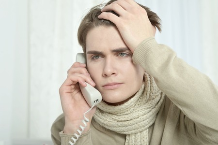 portrait of sick man  calling his doctorの写真素材