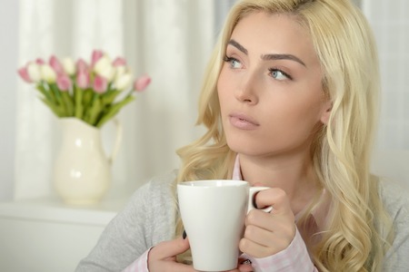 young beautiful woman  drinking tea at homeの写真素材