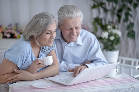 happy senior couple with laptop  at homeの写真素材