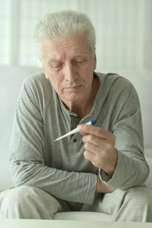 portrait of Sick mature man with thermometerの写真素材
