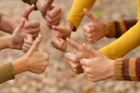 Thumbs up gesturing over natural background close-upの写真素材