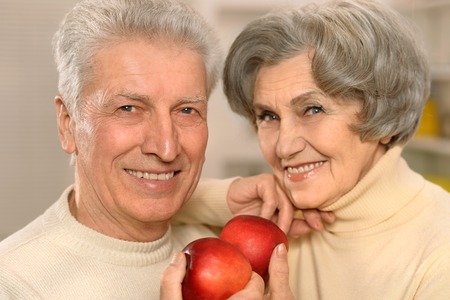 Portrait of beautiful elderly couple with applesの写真素材
