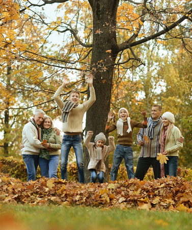Happy smiling family relaxing in autumn forestの写真素材
