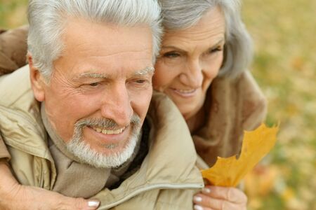 Portrait of a happy senior couple in autumn park