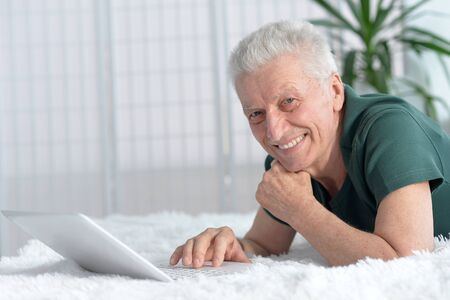 Portrait of a happy senior man using laptop