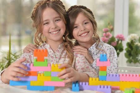 Portrait of two smiling little girls playing toysの写真素材