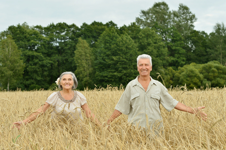 Beautiful happy senior couple in summer fieldの写真素材