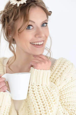 Portrait of a smiling young beautiful woman drinking teaの写真素材