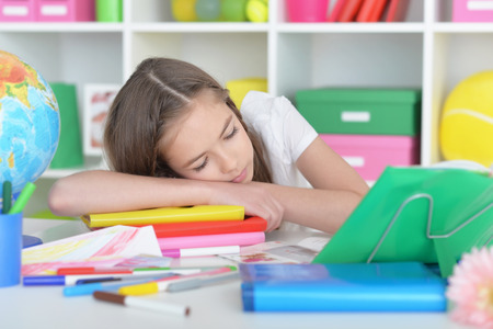 Cute  student girl sleeping on books at class