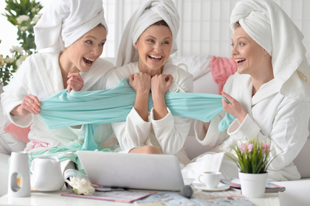 beautiful young women wearing a white bathrobes with laptopの写真素材