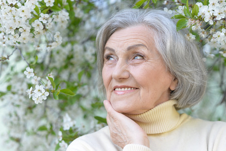 portrait of Older woman with flowers in parkの写真素材