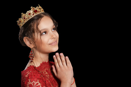 portrait of beautiful  little girl in red dress and crown on black backgroundの写真素材