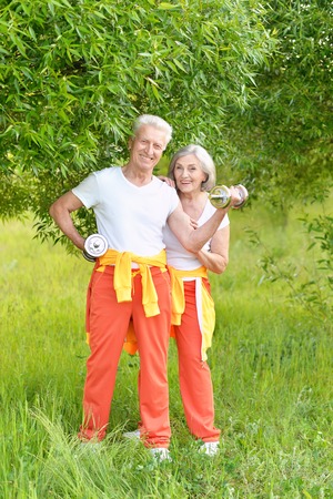 Happy fit senior couple exercising in  parkの写真素材