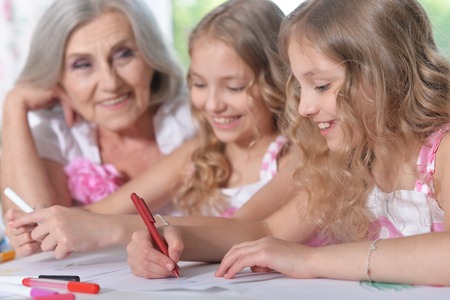 Old woman with tweenie   girls drawing at home