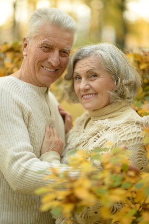 Portrait of a happy senior couple in autumn park