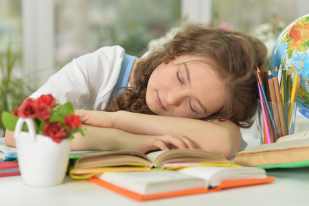Cute  student girl sleeping on books at classの写真素材