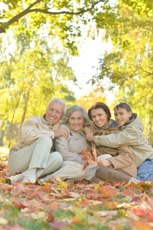 Happy smiling family relaxing in autumn forest