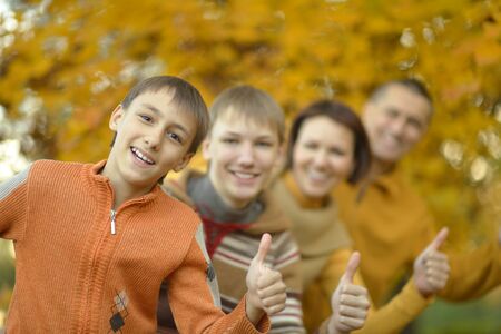 Happy smiling family relaxing in autumn parkの写真素材