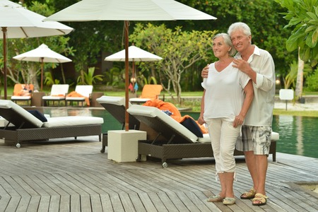 Senior couple relaxing near pool at hotel resortの写真素材